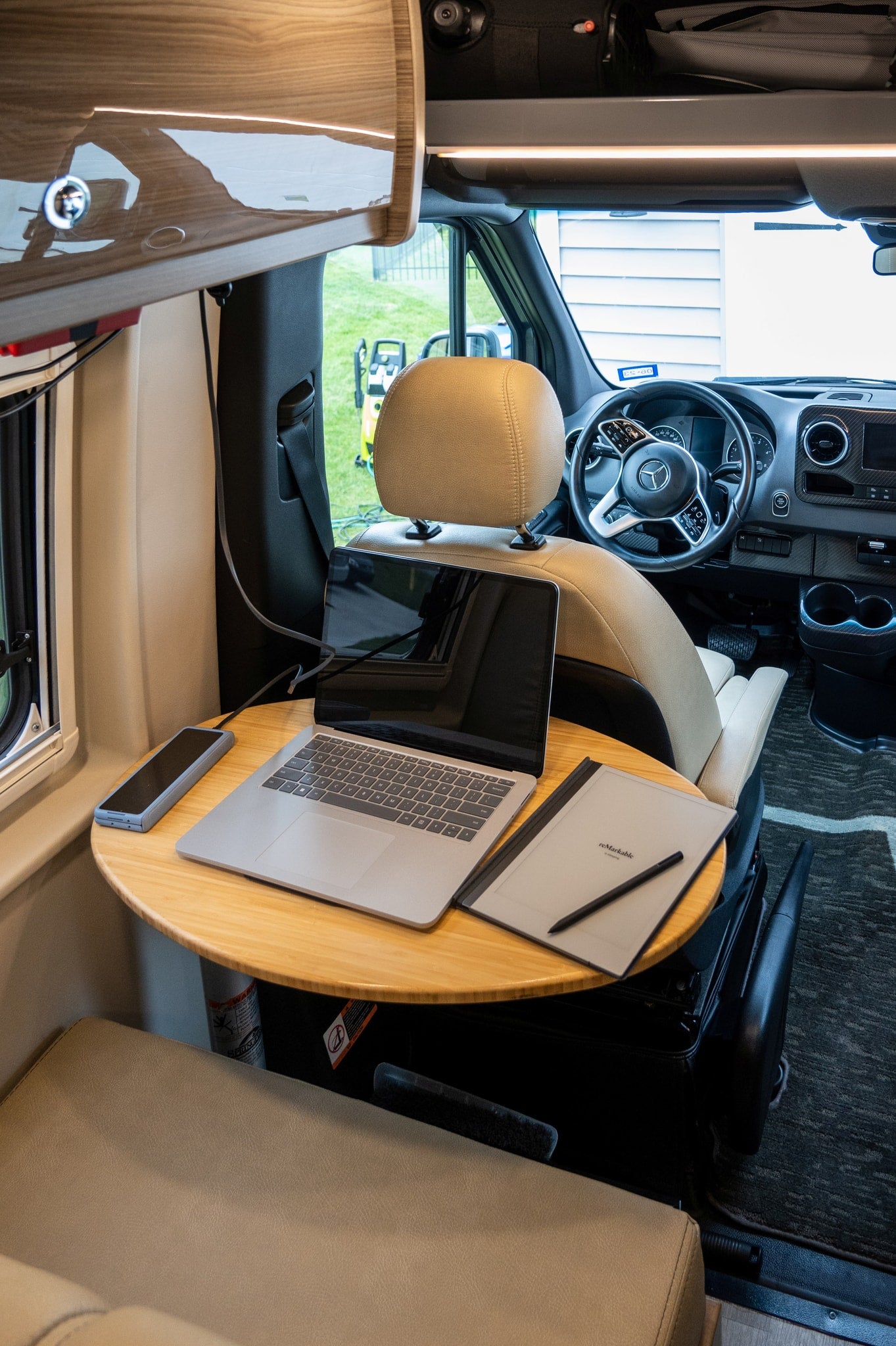 and compact kitchen. Ideal for a comfortable road trip.|This RV rental interior features a cozy bed with a scenic lake view — photo 12