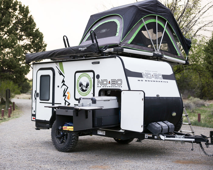 is an ideal rv rental for off-grid camping.|Adventure-ready RV rental setup: a white truck towing an off-road trailer with a deployed rooftop tent and ladder