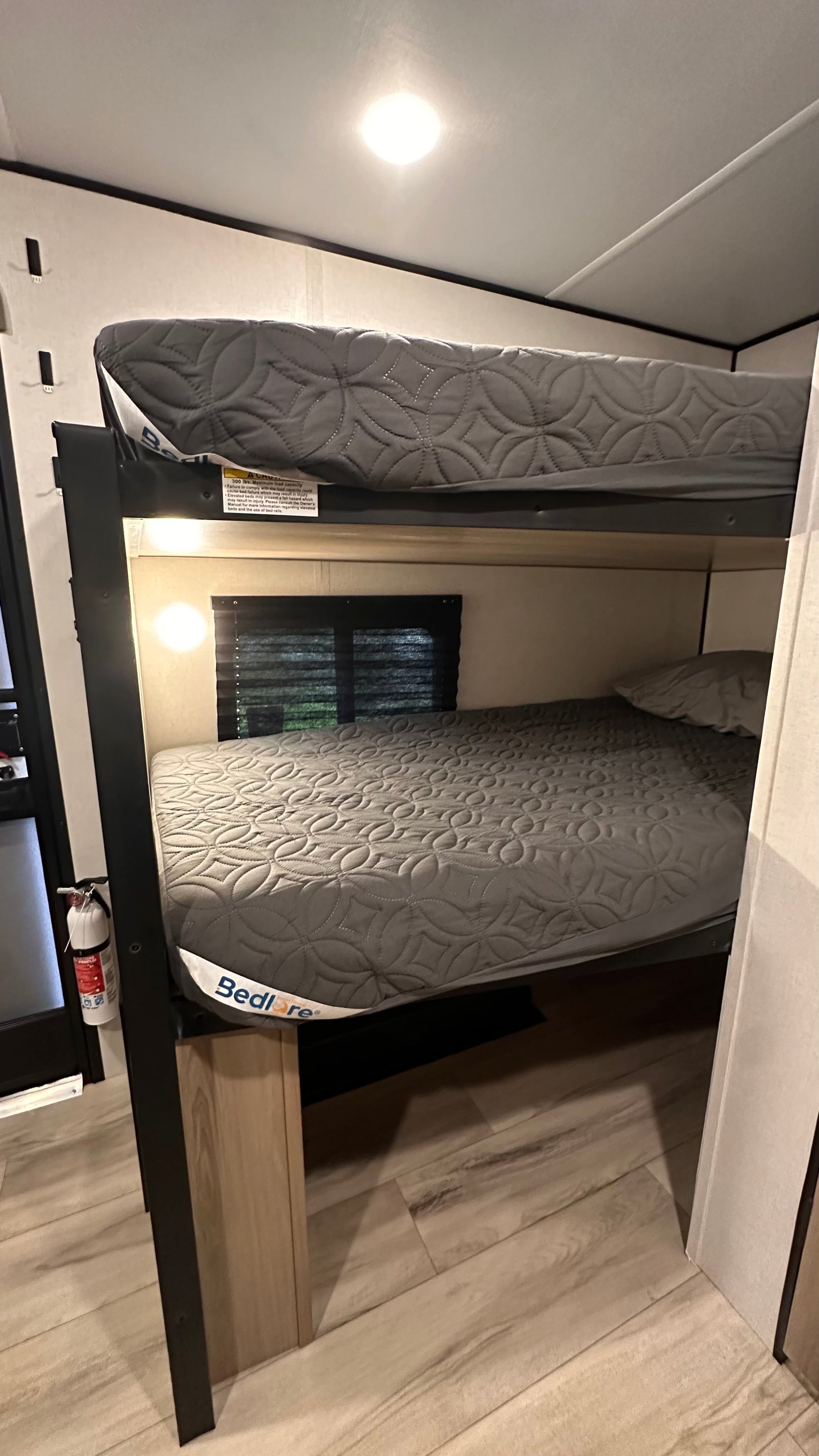 RV rental interior shows bunk beds with mattresses. A warning label on the upper bunk states 300 lbs max capacity.