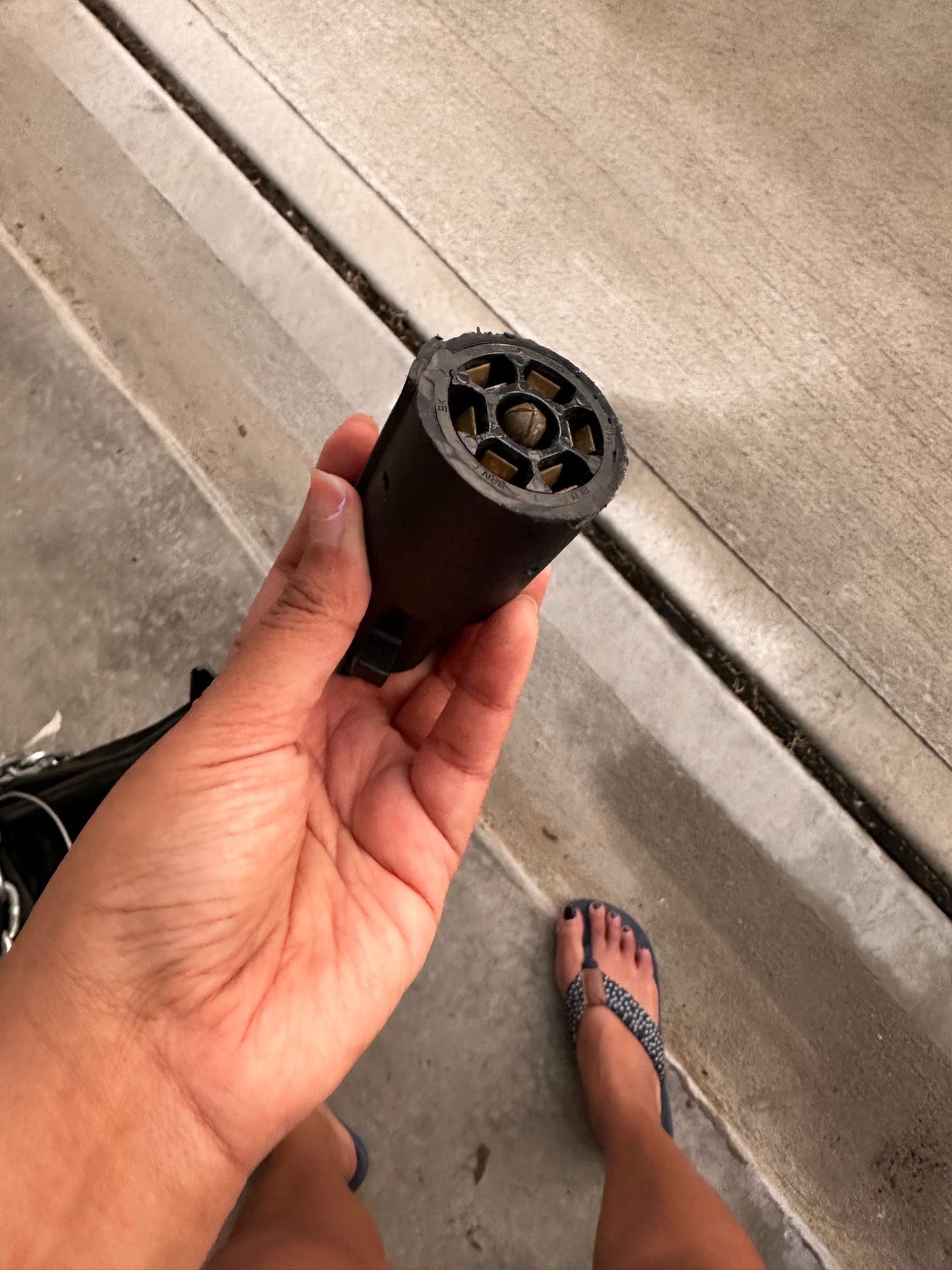 Hand holds a 7-pin RV trailer electrical connector, showing its pin layout. Essential for RV rental towing hookups.