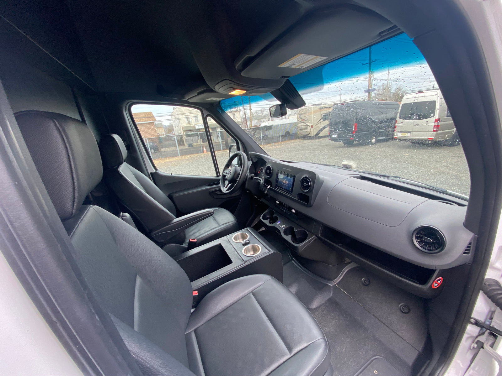 Spacious Mercedes Sprinter van interior, with comfortable front seats & modern dashboard, ready for RV rental adventures.