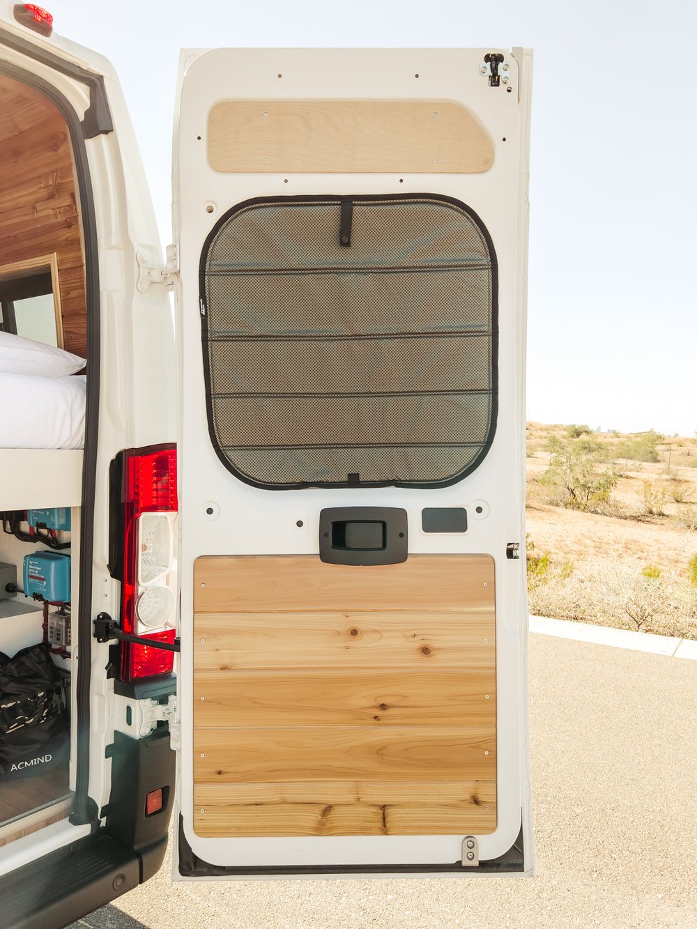 Explore an RV rental's rear door: custom wood paneling, bug screen, and glimpse of the bed & electricals inside. Ready for travel!