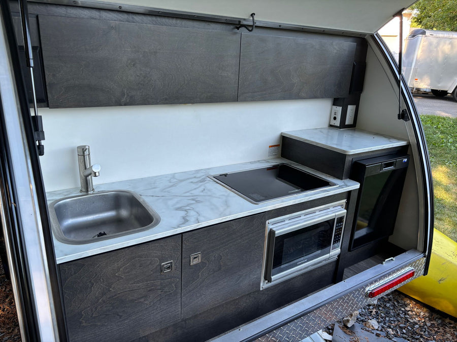 and a window with blinds.|This RV rental's bedroom shows a striped bed