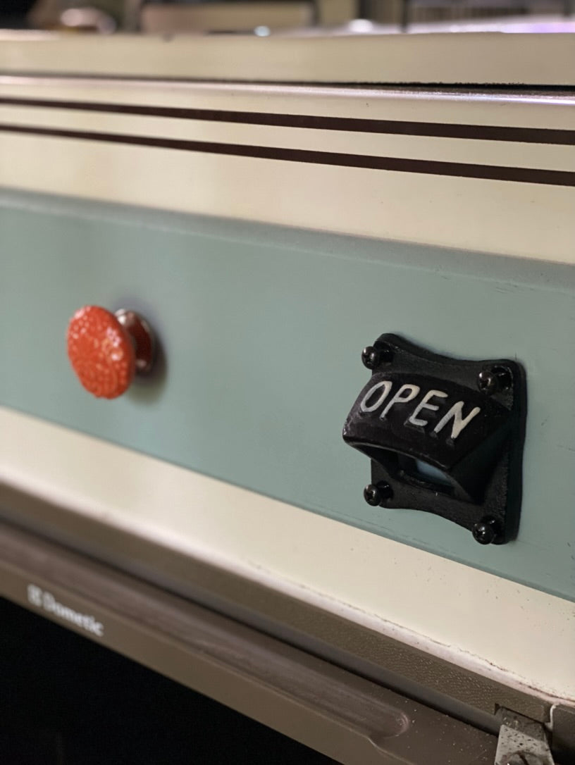 and retro details for travel.|Cozy RV rental interior featuring a kitchenette with teal cabinets
