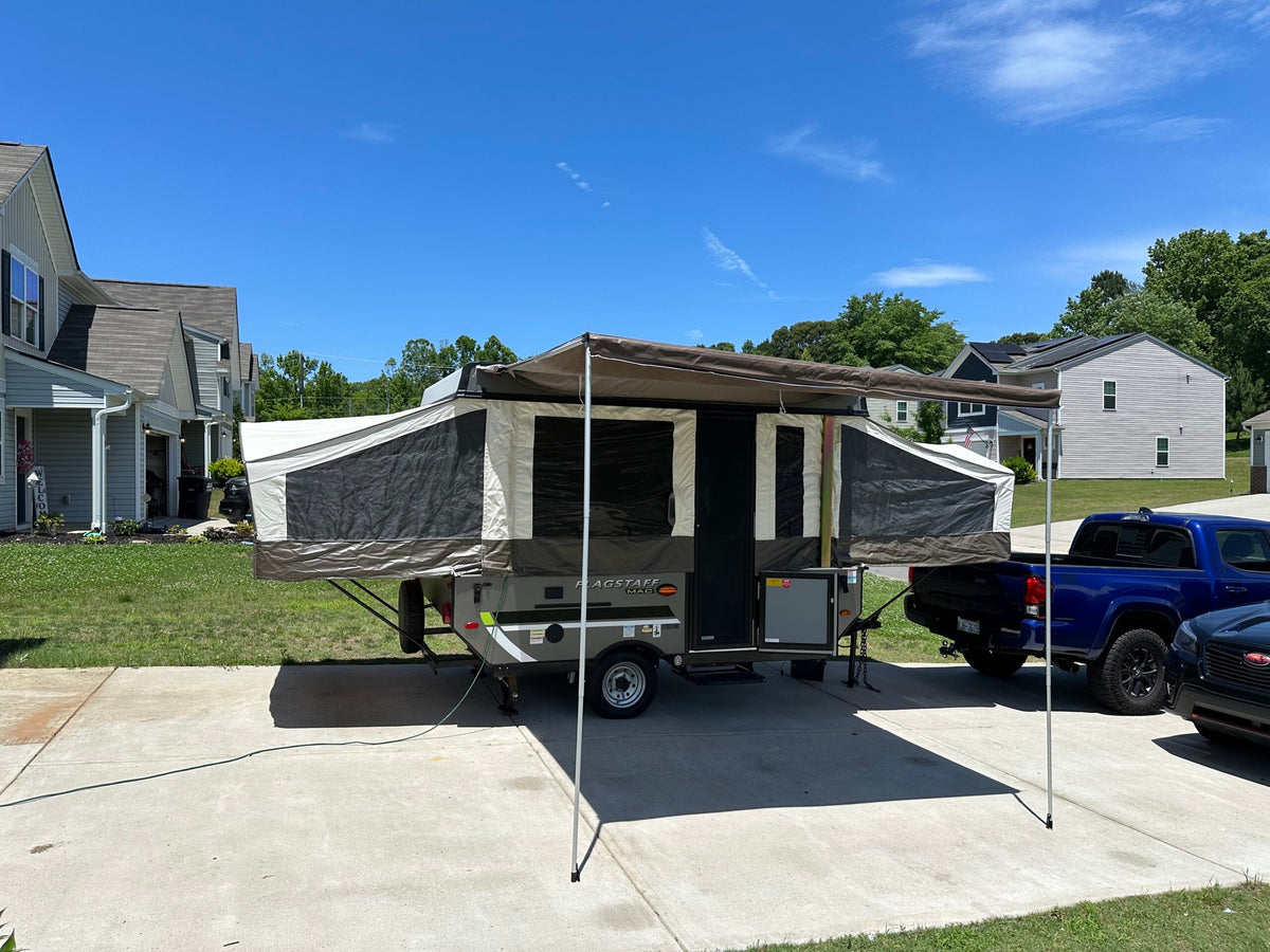 Pop-up RV rental fully set up with an awning in a sunny residential driveway, ready for your next adventure. — photo 2