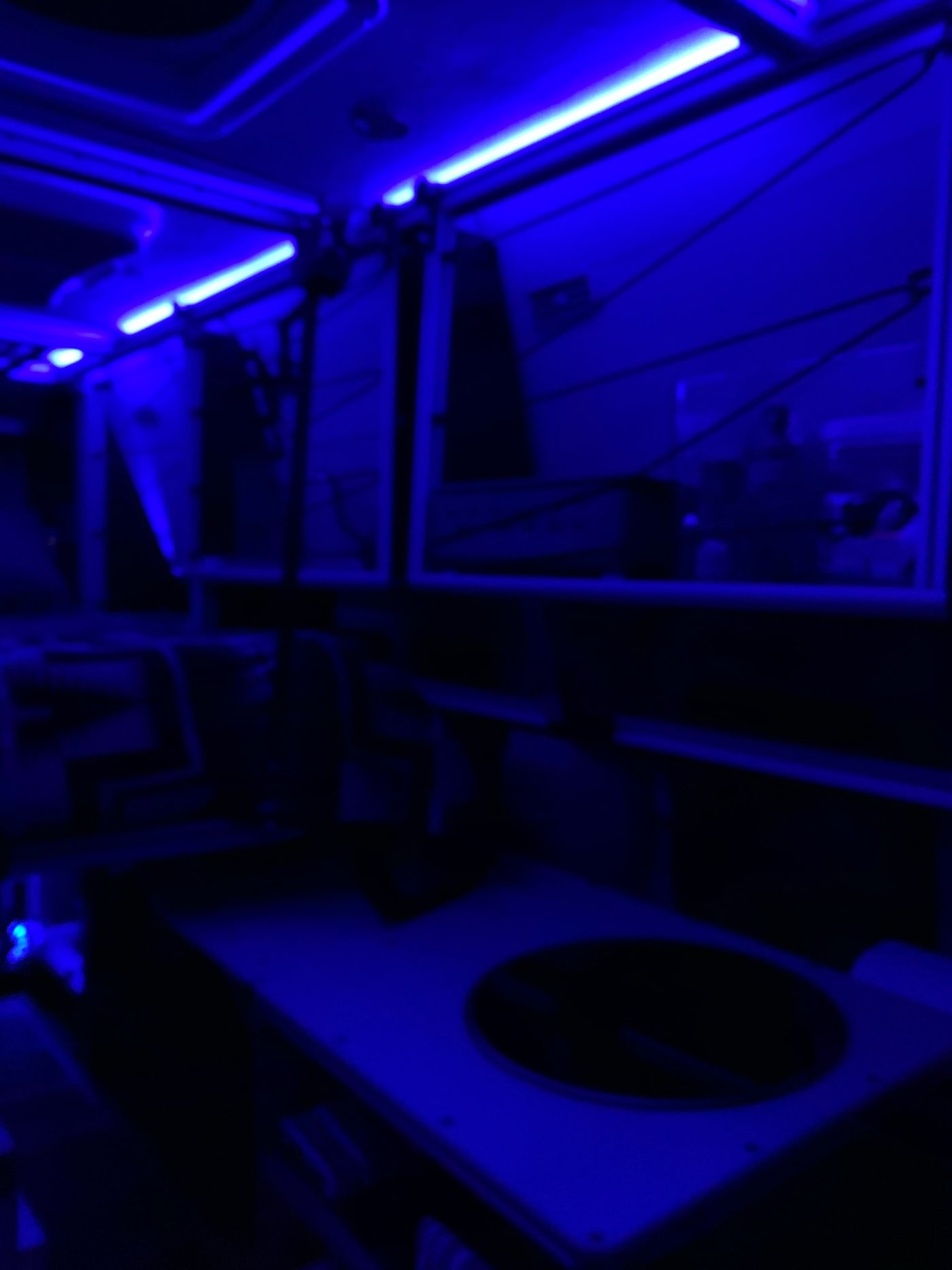 An RV rental's modern interior glows with blue light. The cabin is dark, accented by bright strips for a unique travel experience. — photo 13