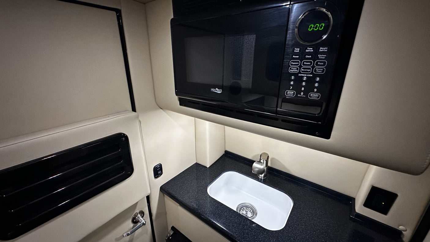 RV rental interior featuring a practical kitchenette with a High Pointe microwave, compact sink, and counter space.