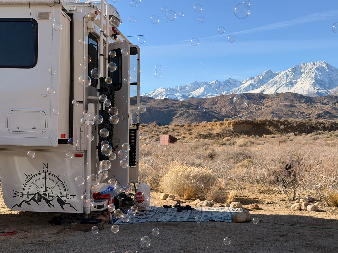 Bubbles enhance an RV rental with a scenic view of snow-capped mountains & desert. Perfect outdoor fun.