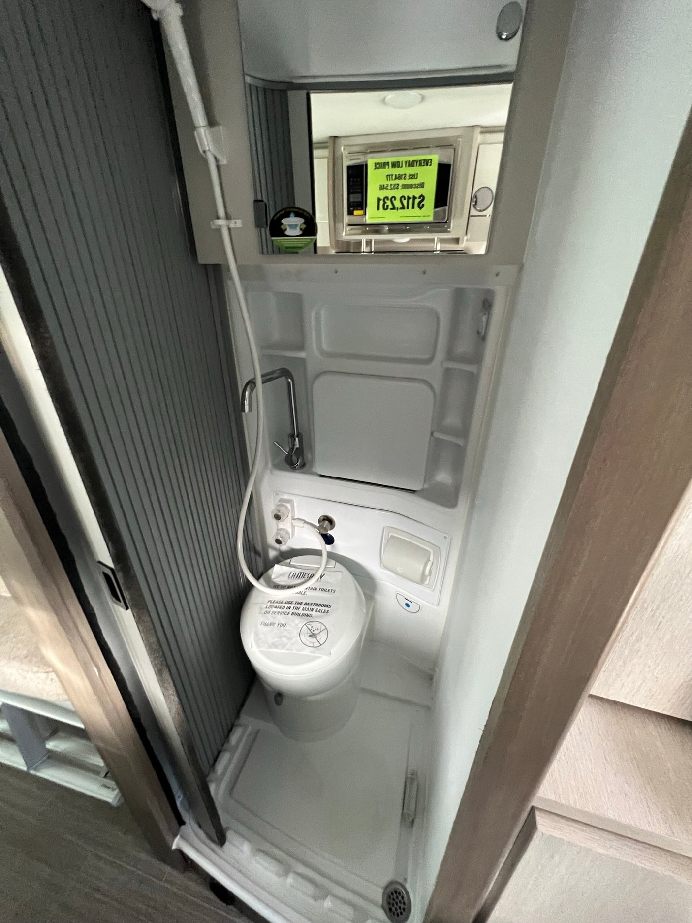 Inside an RV rental, showing a compact wet bath with a toilet, shower, and sink. Essential for on-the-go travel.