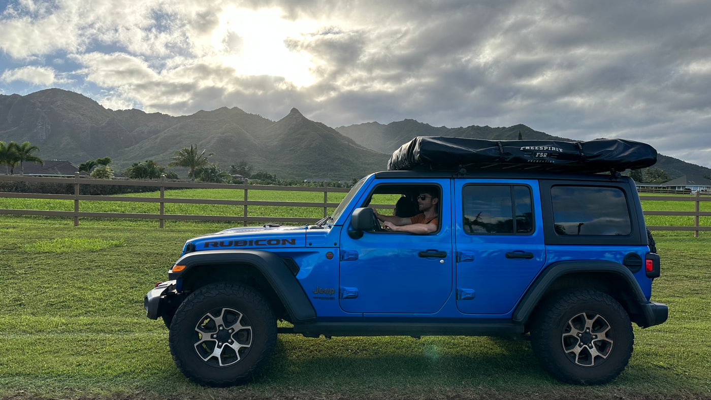 Explore scenic trails in this blue Jeep Rubicon with rooftop tent – an ideal RV rental for off-road adventures. — photo 4