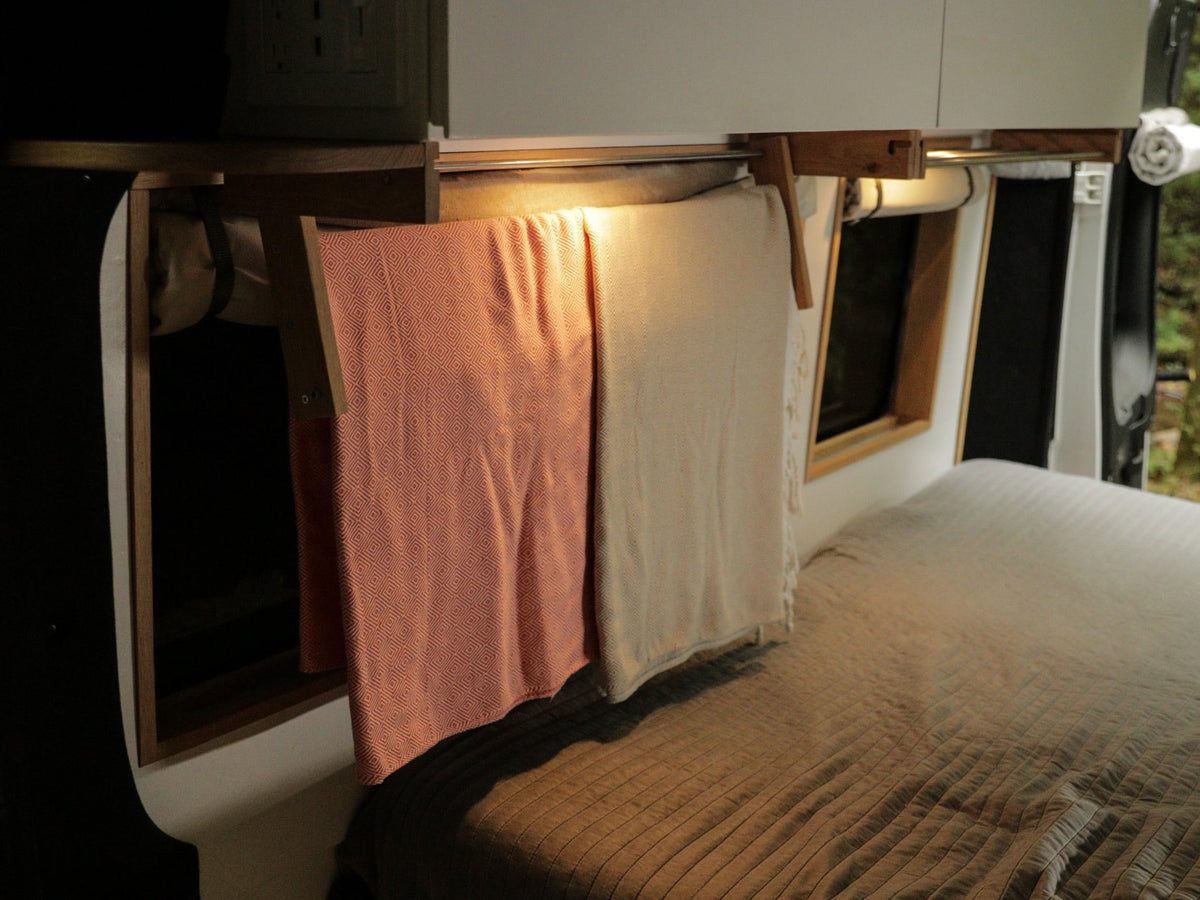 compact kitchen with stove and fridge on wooden floor. Forest views ahead.|Open Isotherm fridge in an RV rental — photo 17