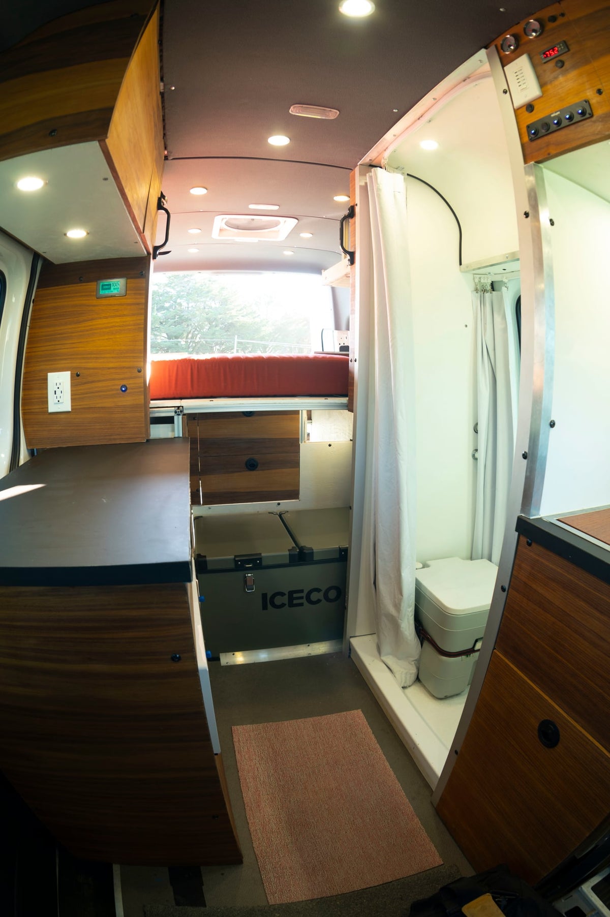and private toilet area for comfortable travels.|Spacious RV rental interior: view of front cabin with dashboard — photo 13