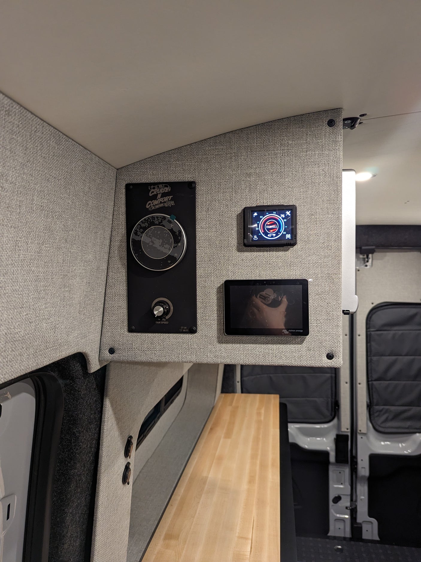 RV rental interior: A detailed shot of the control panel featuring a Cruise N Comfort unit, Elwell thermostat, and Victron Energy monitor.