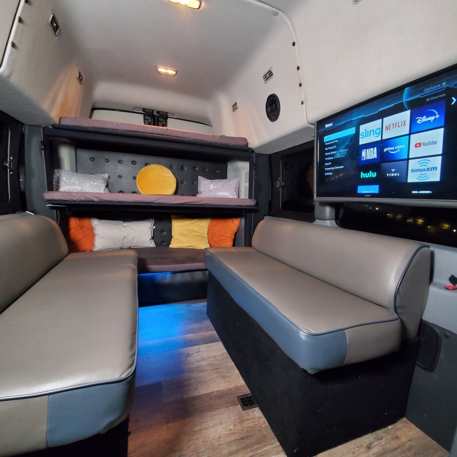Inside an RV rental: plush seating, bunk beds, and a TV with streaming apps like Netflix and Hulu for your journey.