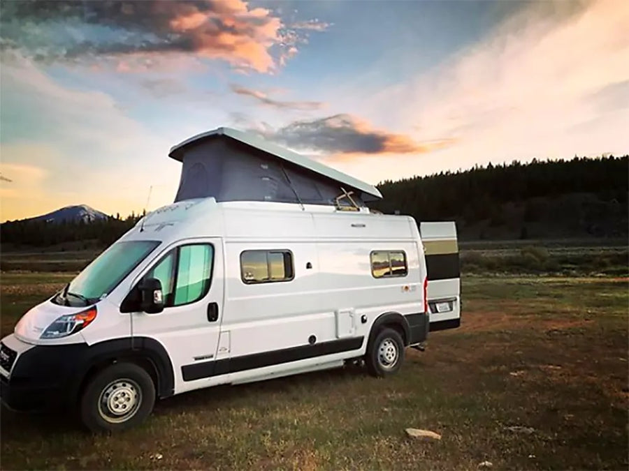 White pop-top RV rental in a scenic field
