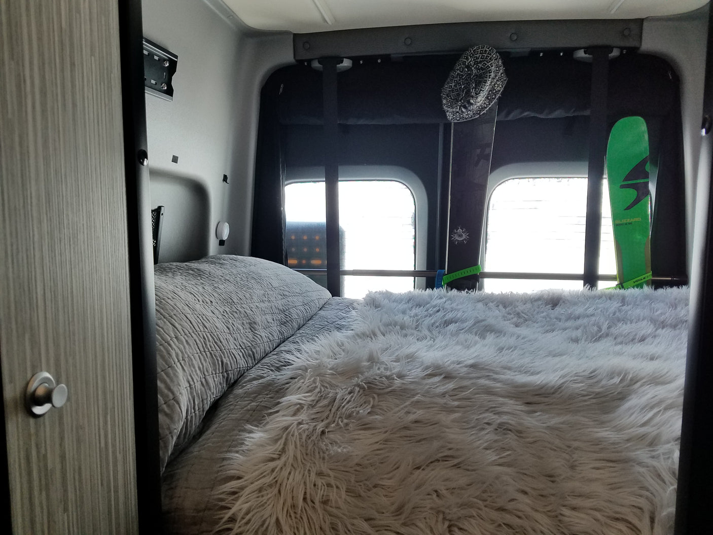 Experience comfort in this RV rental's sleeping area, complete with a cozy bed and integrated ski storage.