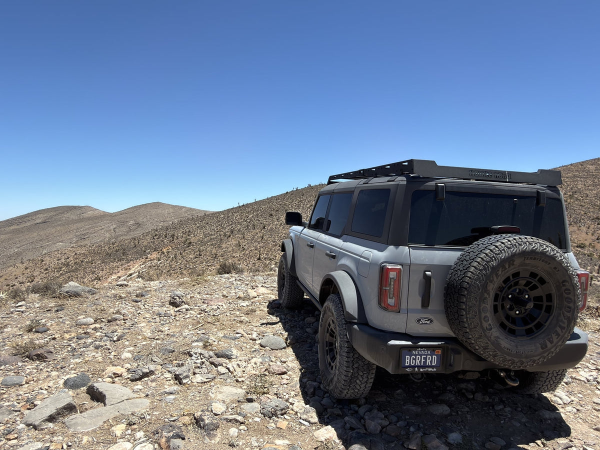 great for an rv rental exploring rocky off-road trails.|A grey Ford Bronco conquers a rugged desert trail under a clear sky. Your next adventure awaits — photo 7