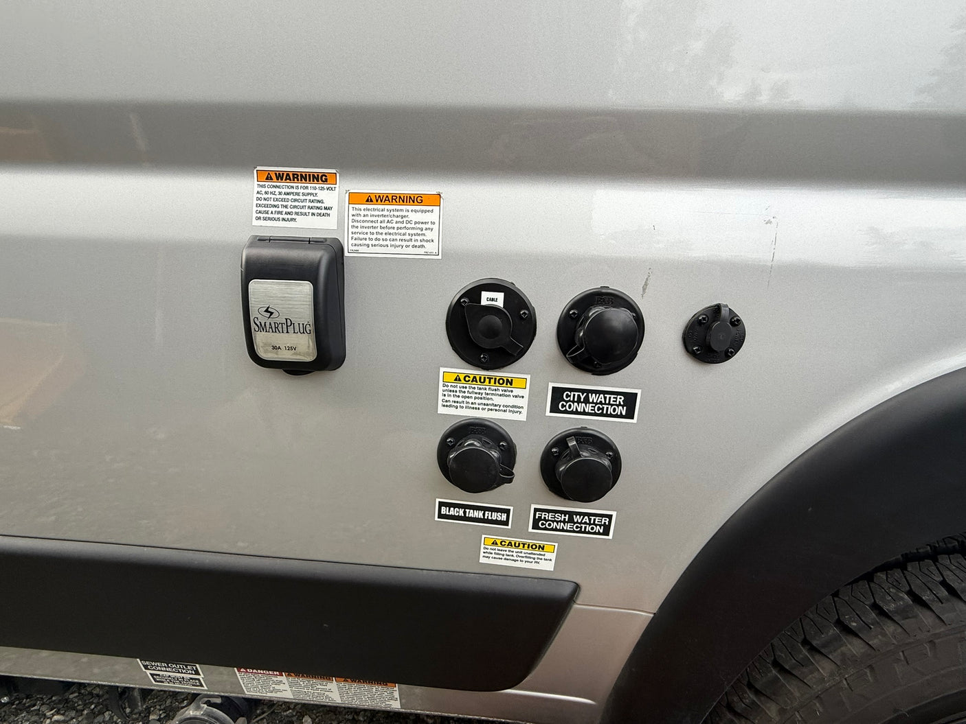 RV rental utility panel: power (30A), cable, city & fresh water, and black tank flush connections on the side.