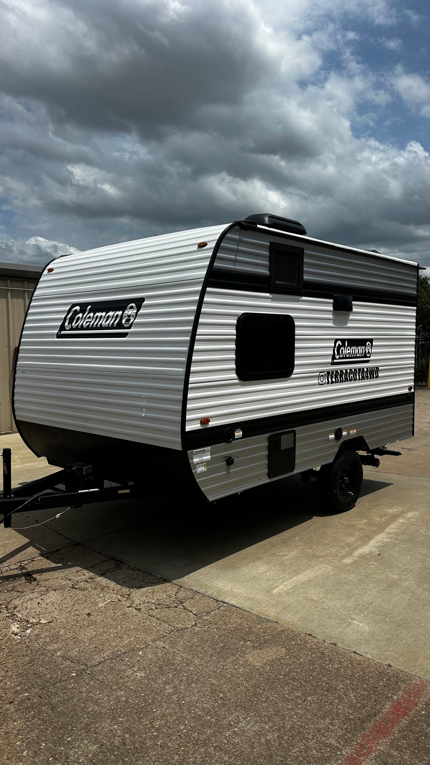 White and grey Coleman travel trailer with black trim, ideal for your rv rental camping trip.
