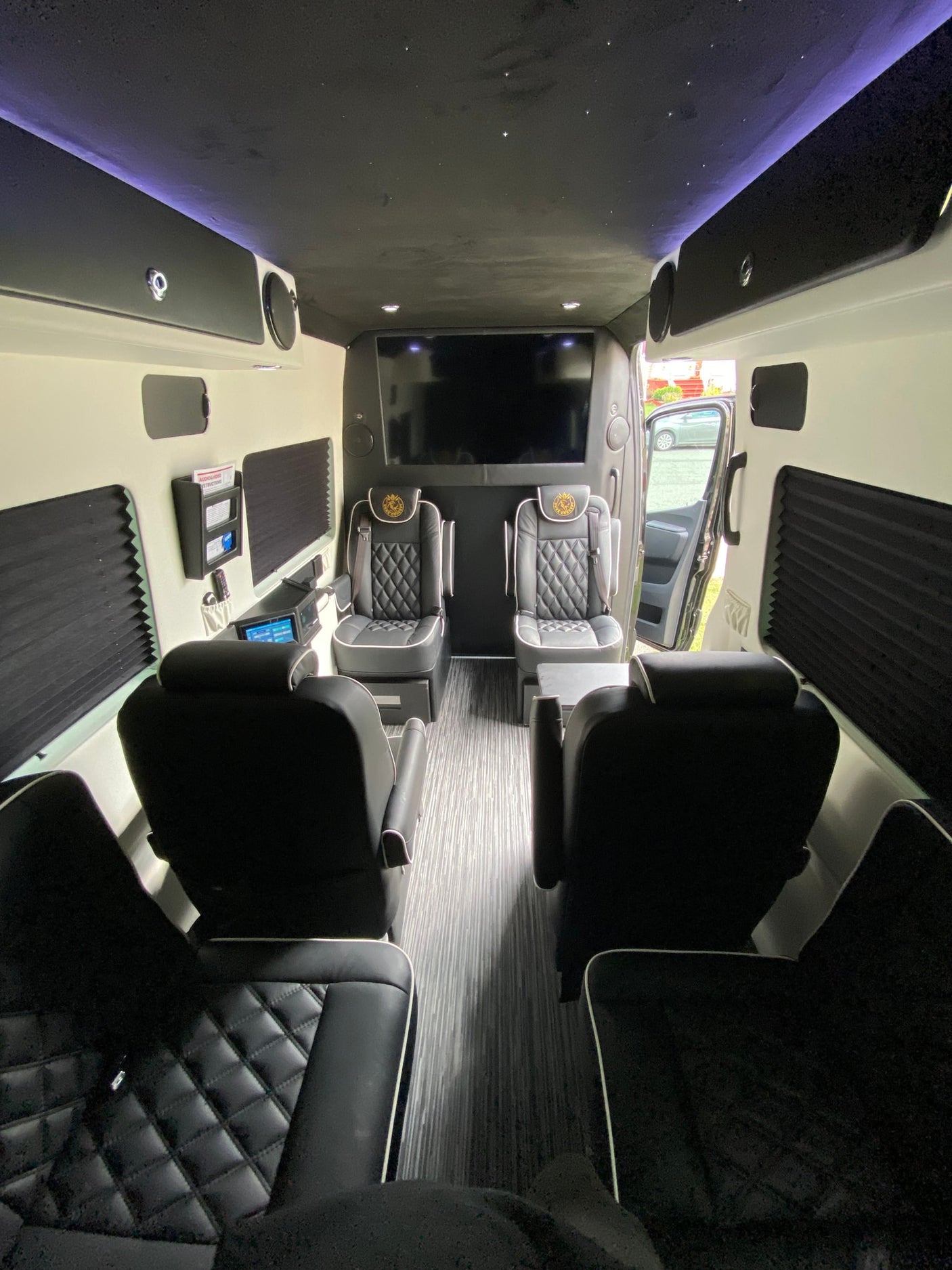 Step inside this luxury RV rental: featuring custom seating, a starry ceiling, and a large entertainment system for ultimate comfort.