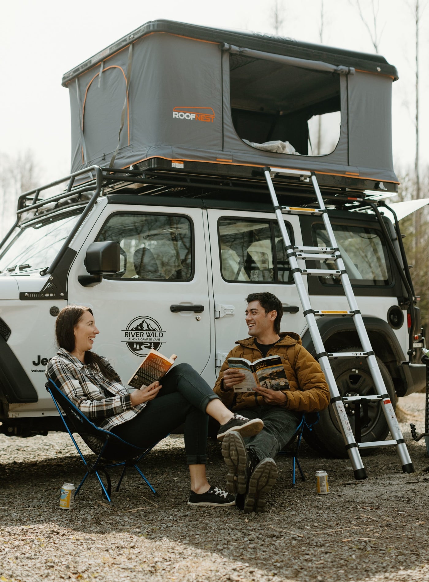 Two people relax by their RV rental, a Jeep Wrangler with a Roofnest rooftop tent, perfect for an Alaska camping adventure. — photo 2
