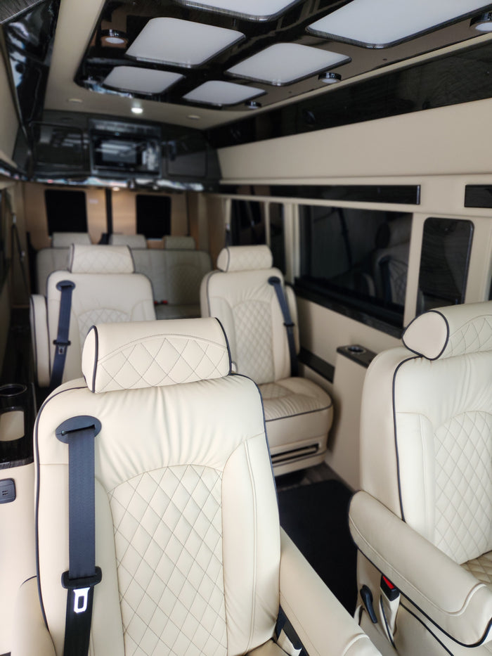 Experience comfort in this luxury RV rental van interior with quilted leather seats and modern lighting, perfect for travel.