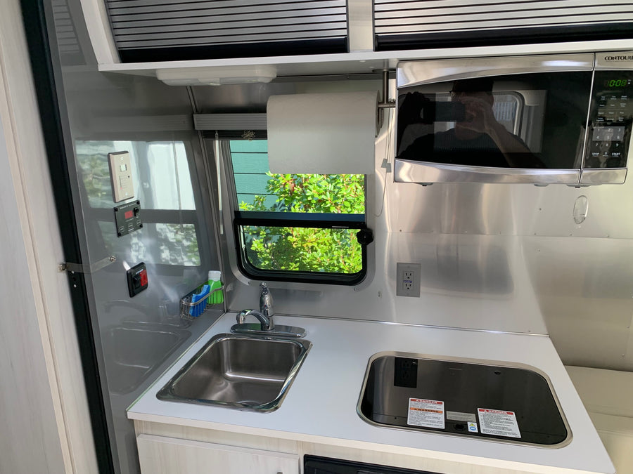 is parked with its door open for adventure.|Airstream Bambi travel trailer