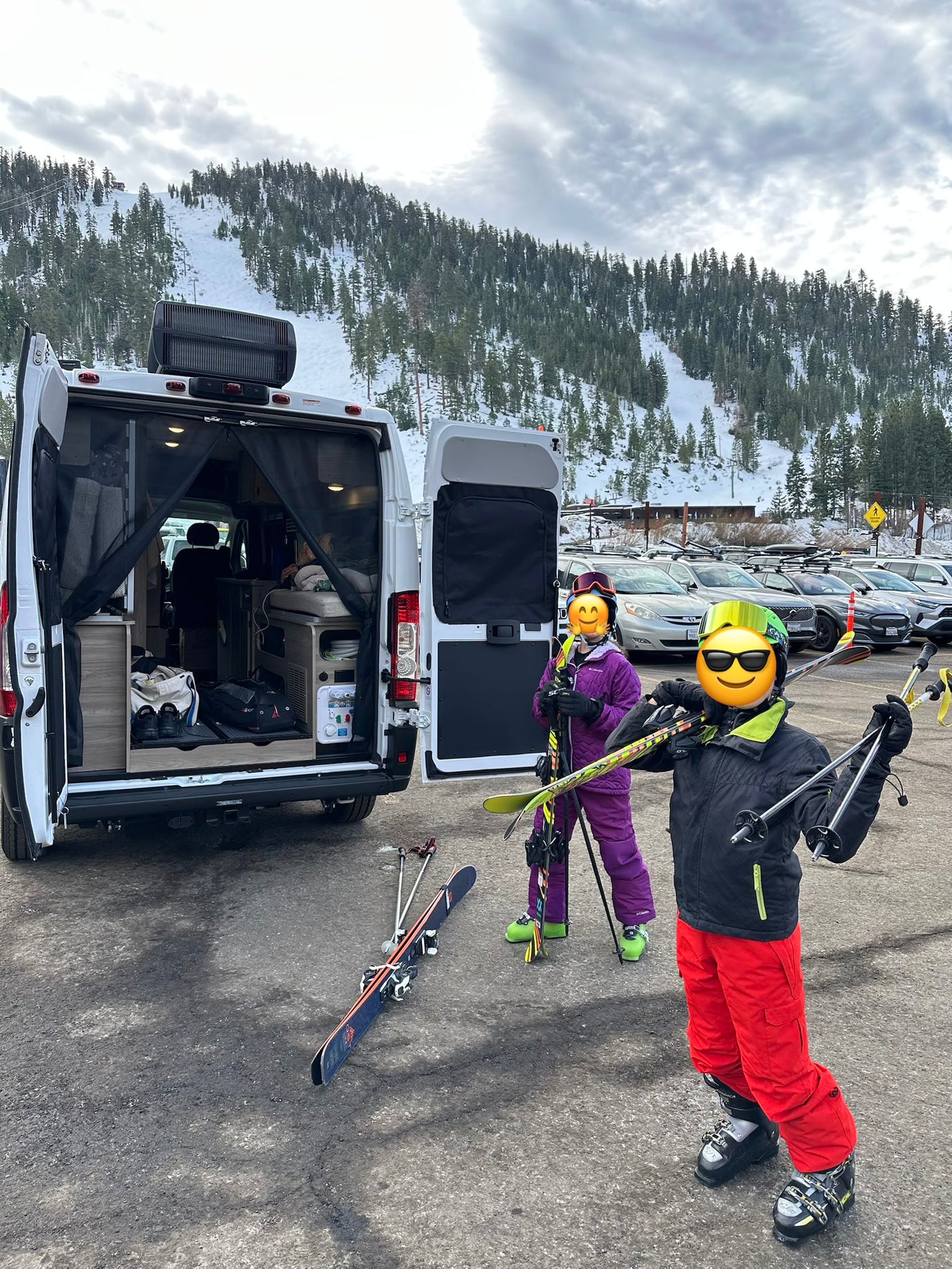 Winter adventure with an RV rental! Skiers with gear stand by their open campervan in a snowy mountain parking lot.