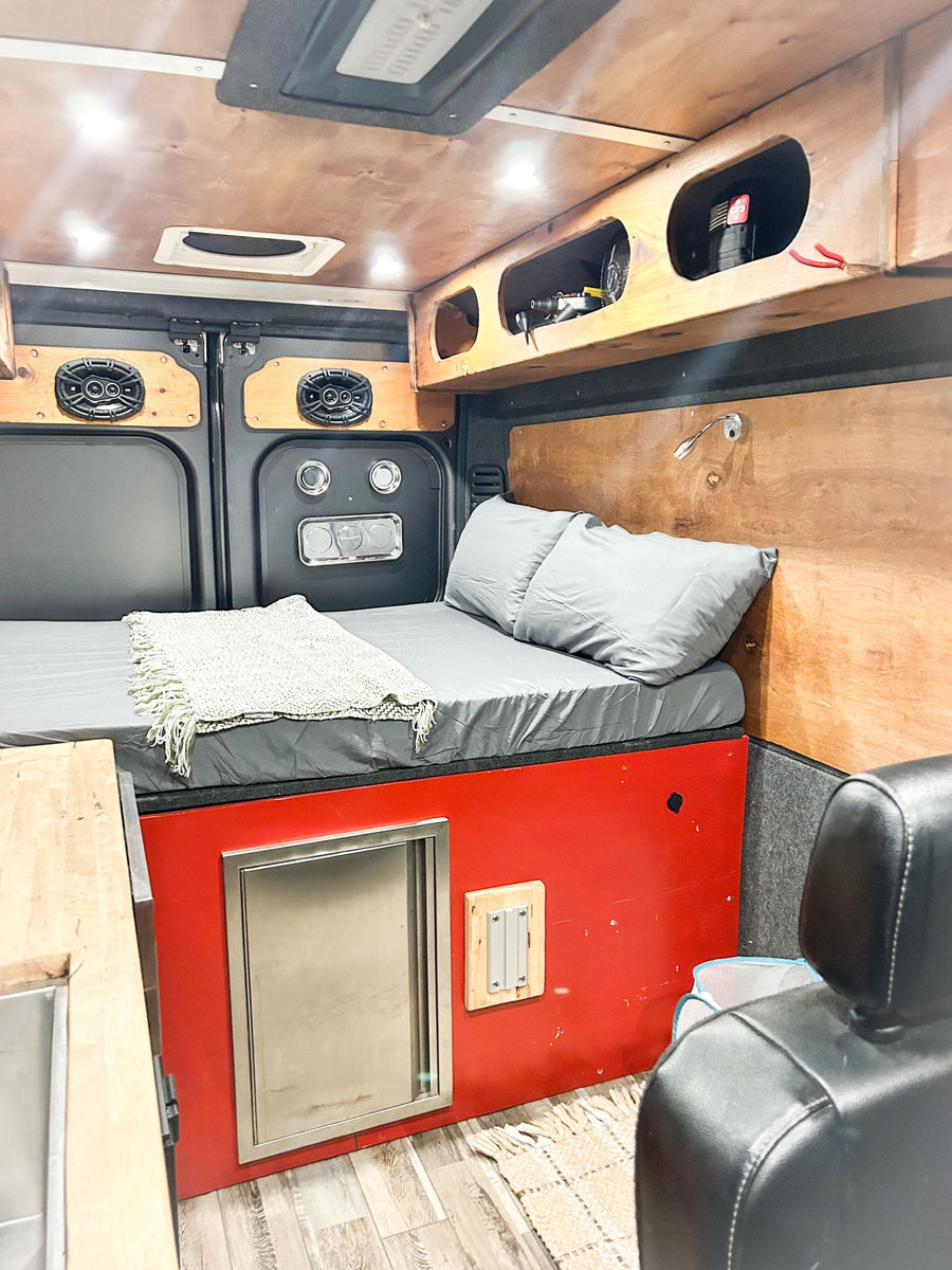 and overhead storage with bags.|RV rental interior: A digital control panel displays "14.0" on wood paneling