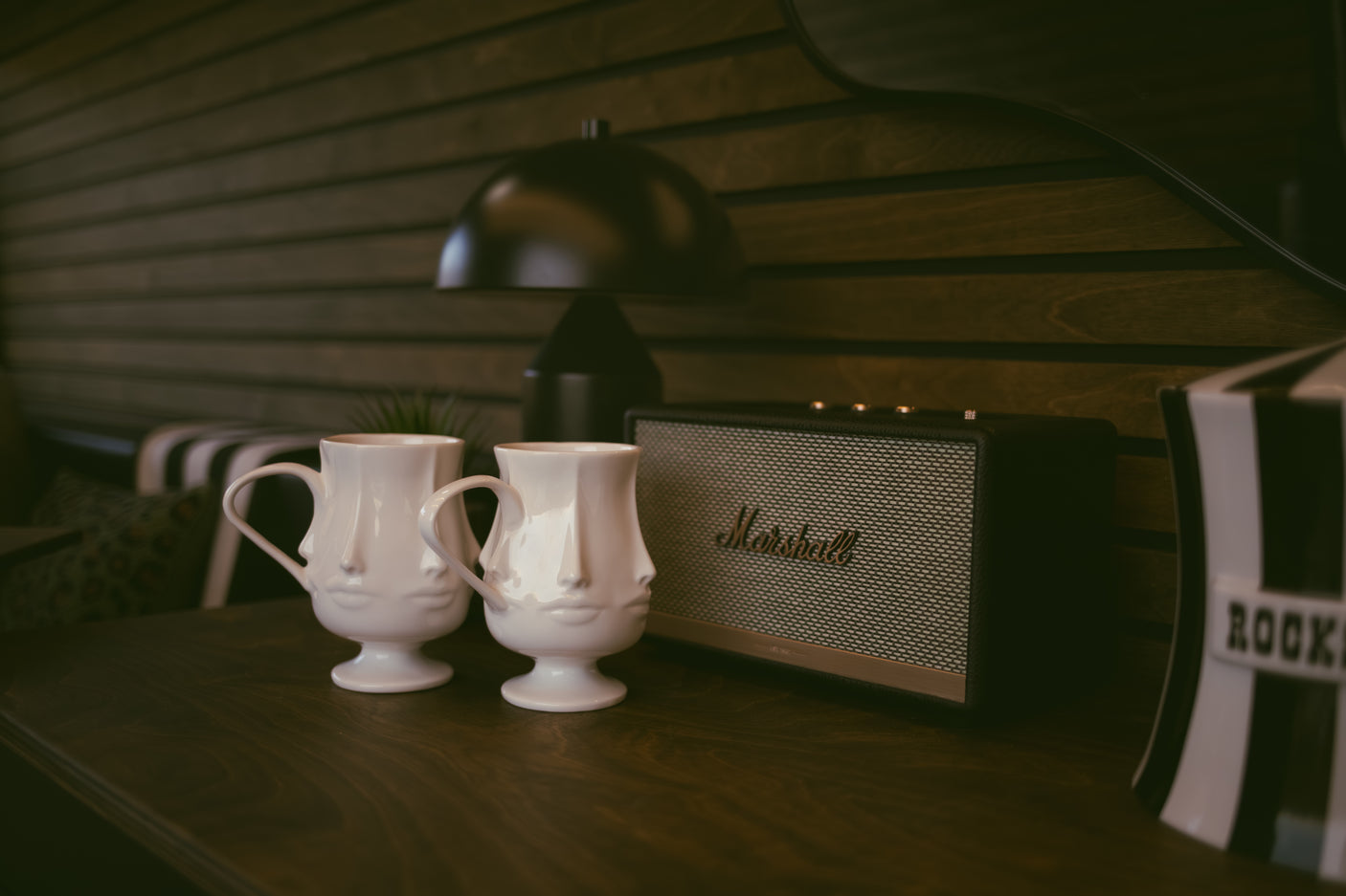 A cozy rv rental interior features unique face mugs, a Marshall speaker, and warm wood paneling, offering stylish comfort.