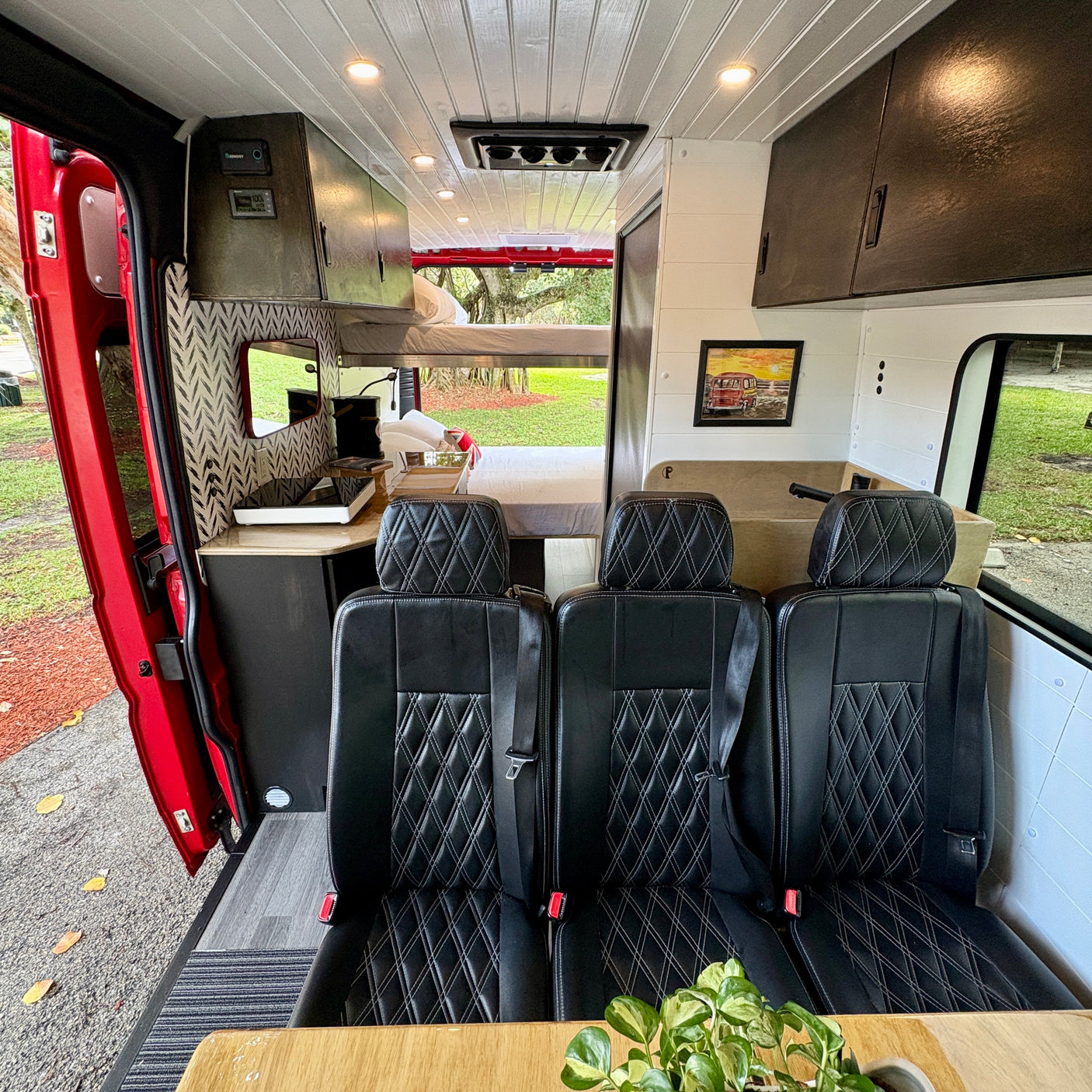 Experience comfort in this RV rental's custom interior: seating for three, a kitchen, and a sleeping area. Ideal for camping & travel.