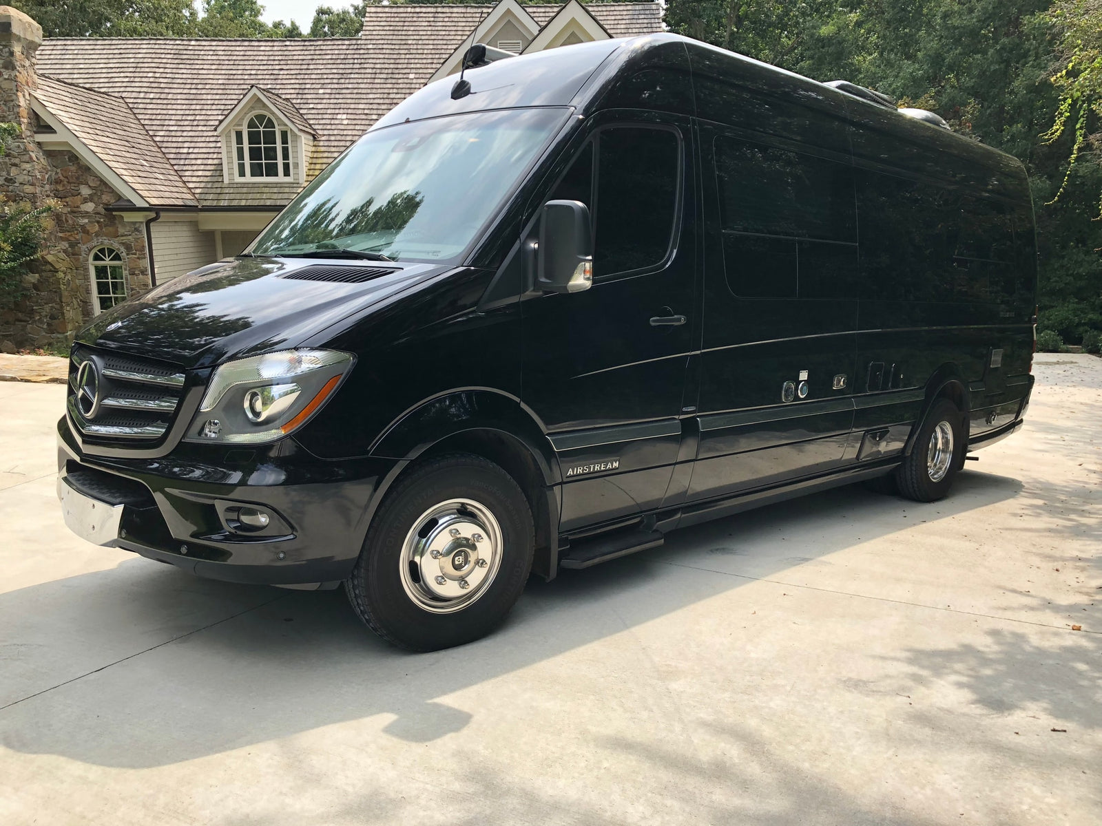 and TV.|Spacious RV rental interior featuring black leather captain seats