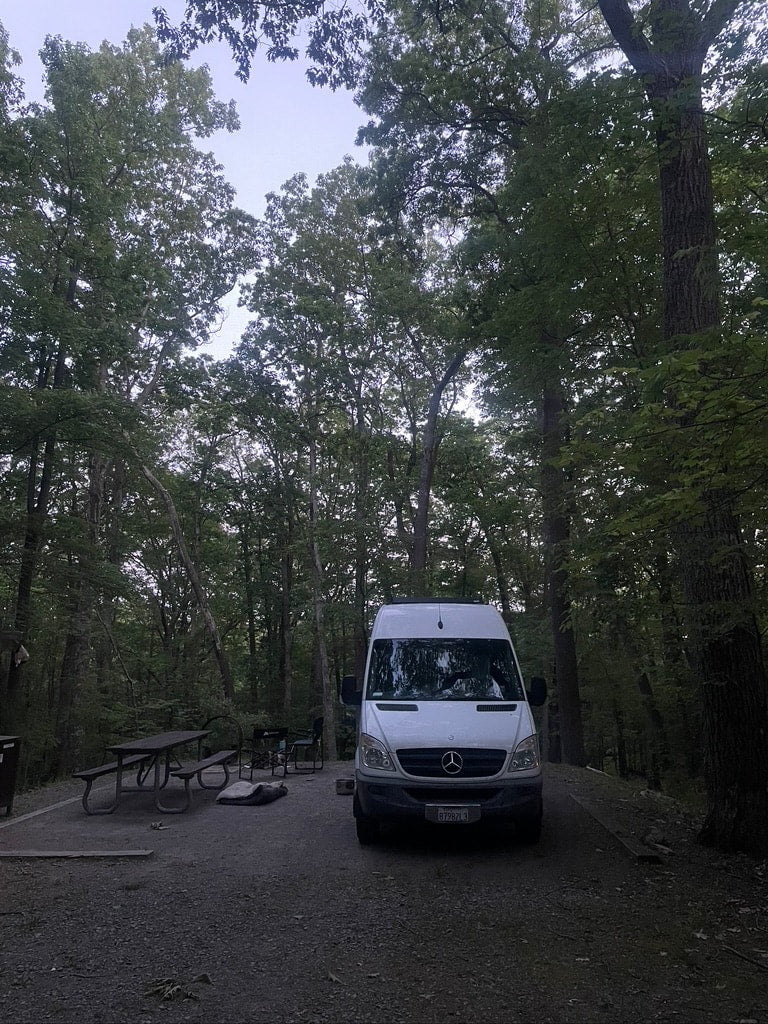 and overhead compartments.|RV rental interior: A compact dining area featuring a butcher block table