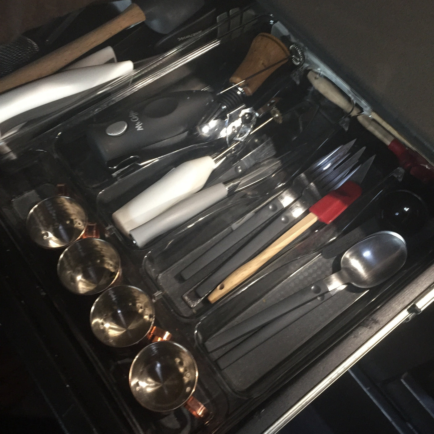 RV rental kitchen drawer: neatly organized with flatware, cooking utensils, measuring cups, and a Mr. Coffee frother.
