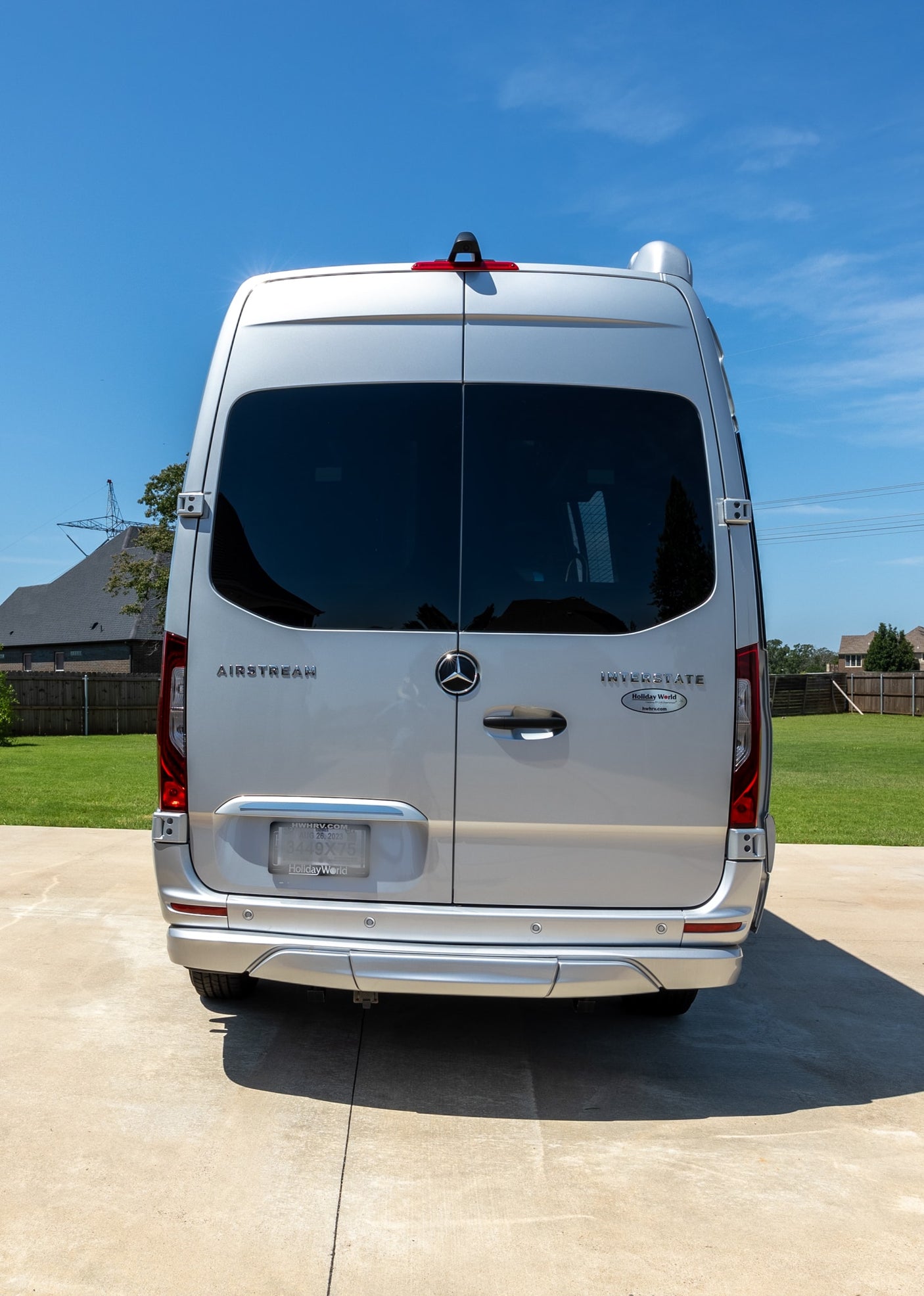 sunny view of a silver Airstream camper van parked on a driveway