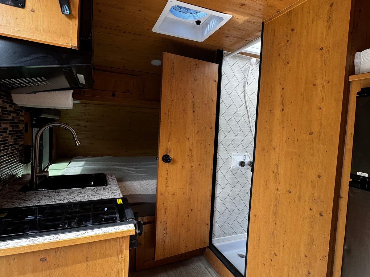 and a cozy dining area.|Inside a cozy RV rental: wood-paneled interior — photo 7