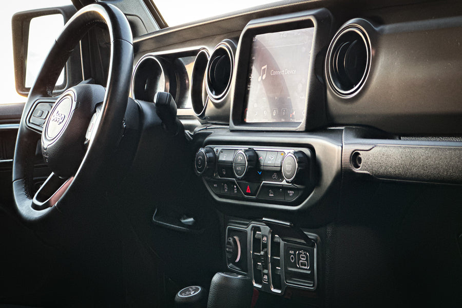 Modern Jeep dashboard: steering wheel, infotainment screen (showing 'Connect Device'), and climate controls. Ideal for RV rental trips.