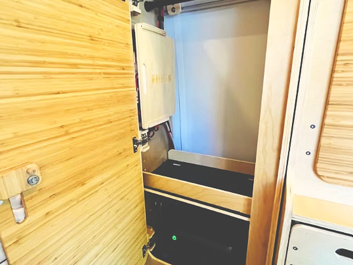 and a cozy bed.|Inside a compact **rv rental**: custom wood paneling — photo 16