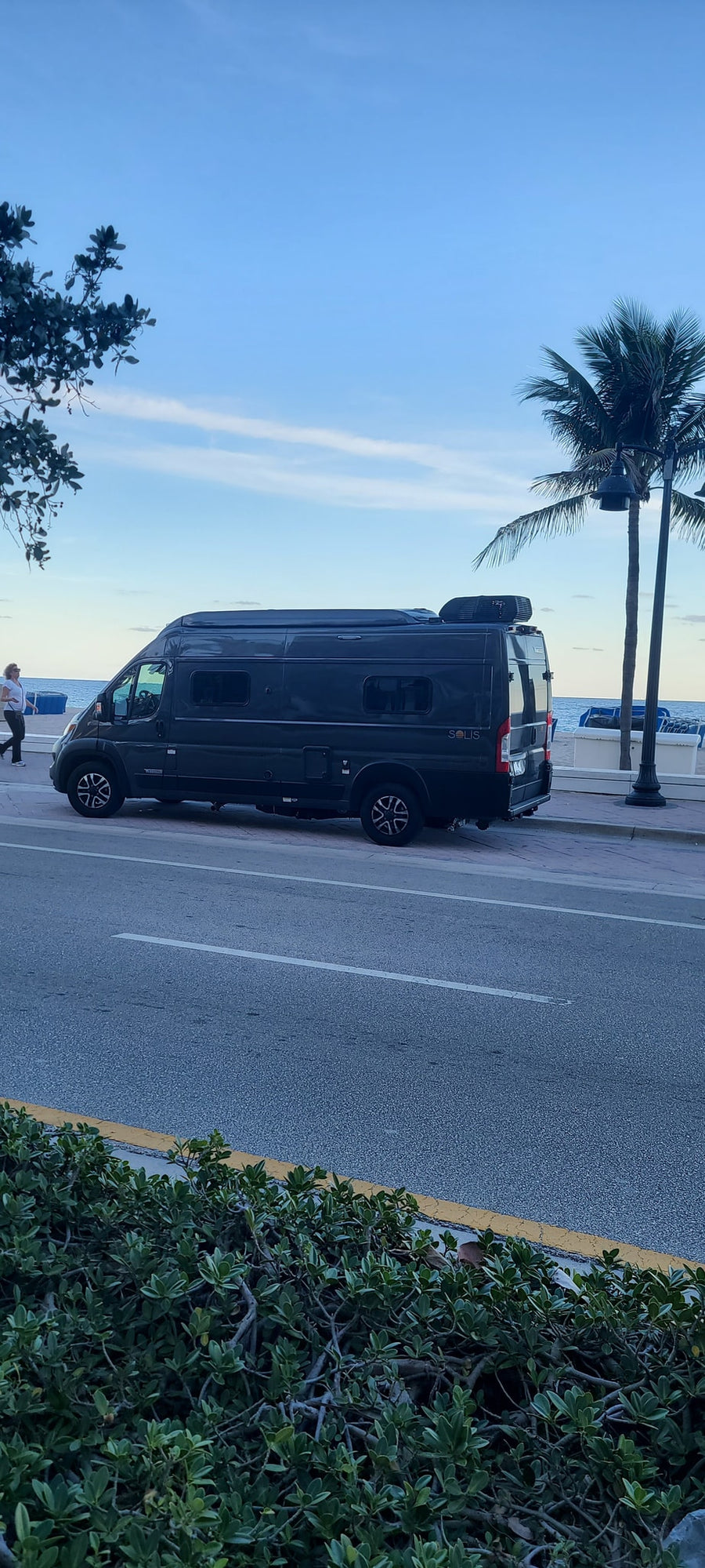 and front passenger area. Ready for your next journey!|Dark grey Winnebago RV rental parked oceanside with door open