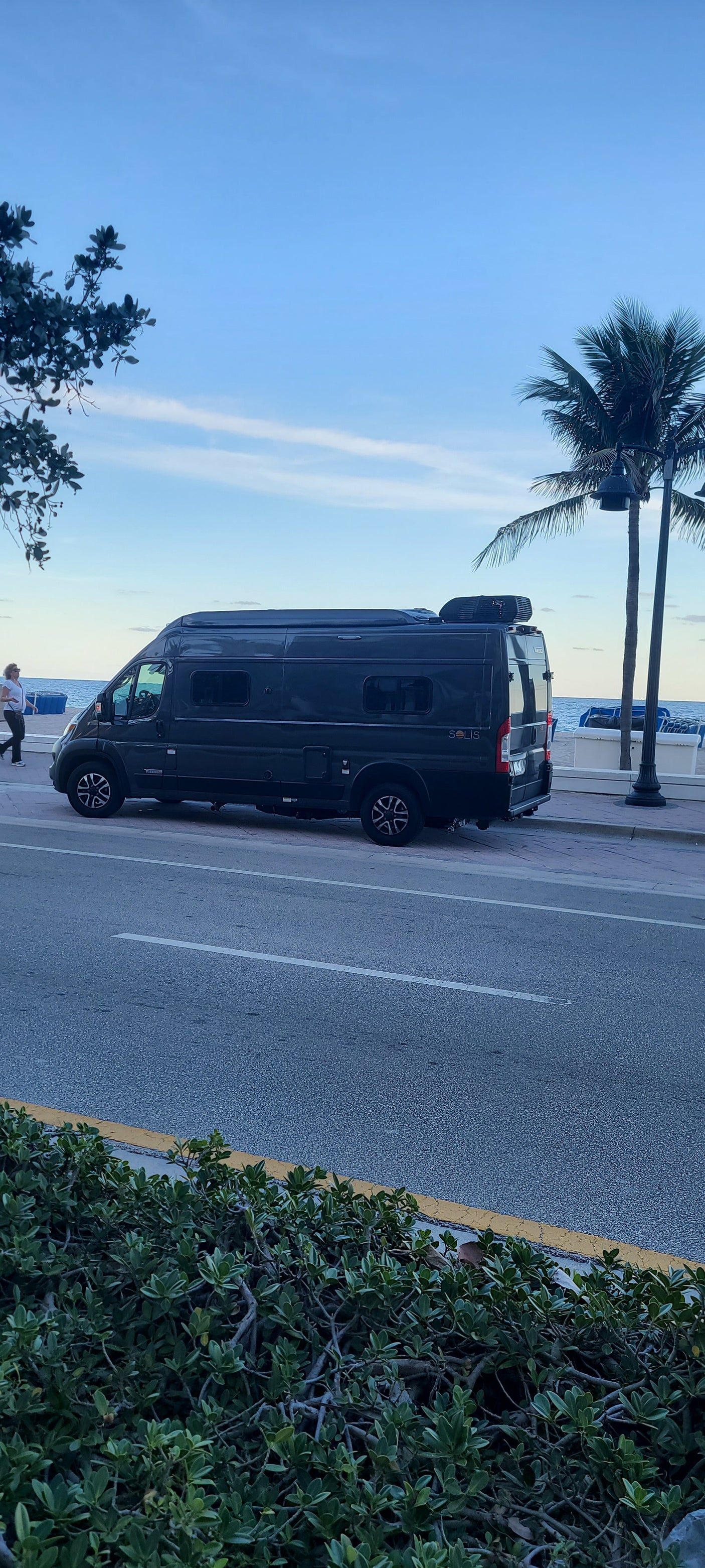 and front passenger area. Ready for your next journey!|Dark grey Winnebago RV rental parked oceanside with door open