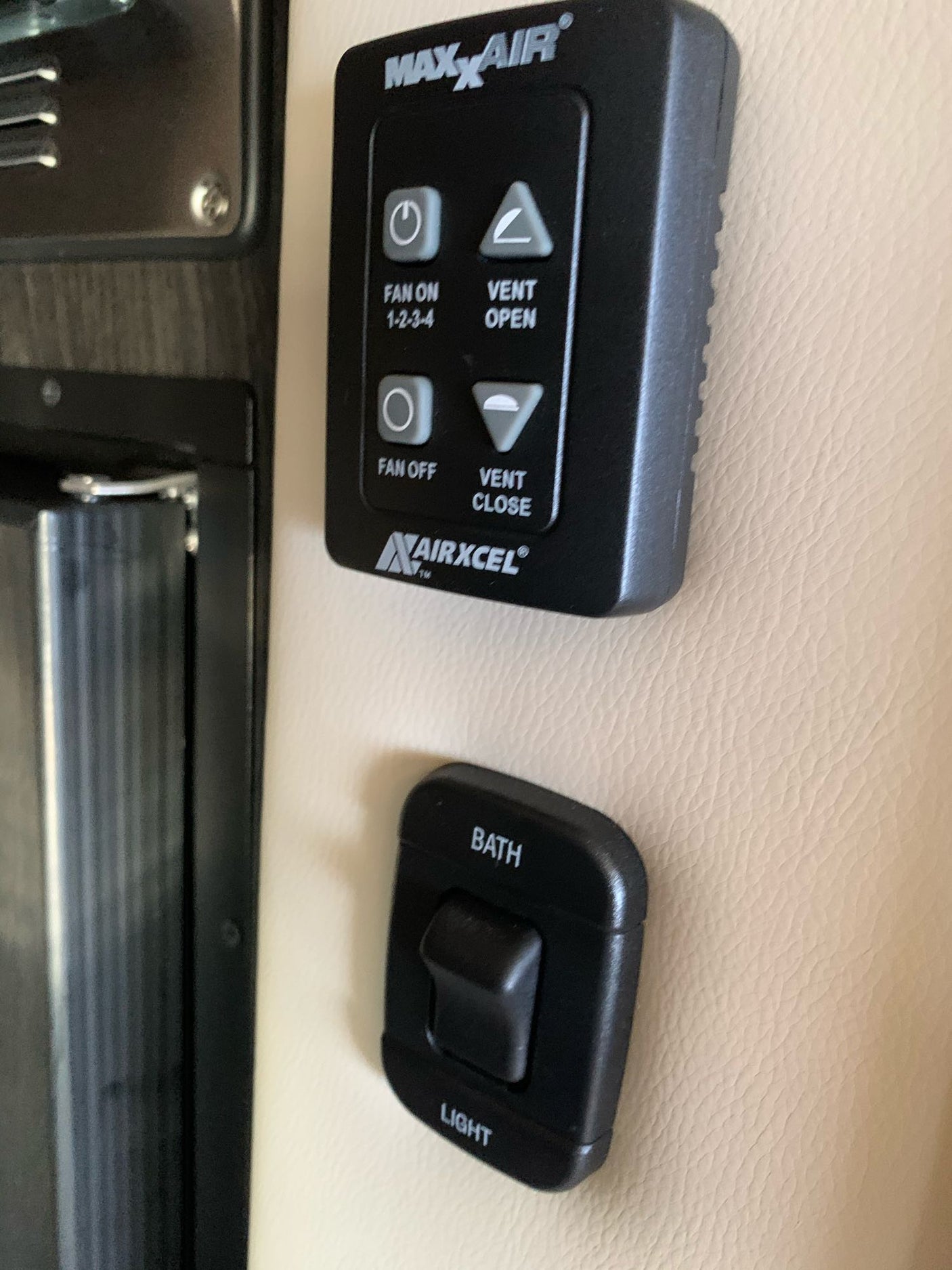 RV rental controls: MAXxAIR fan/vent and bath light panel. Essential for a comfortable RV rental experience.