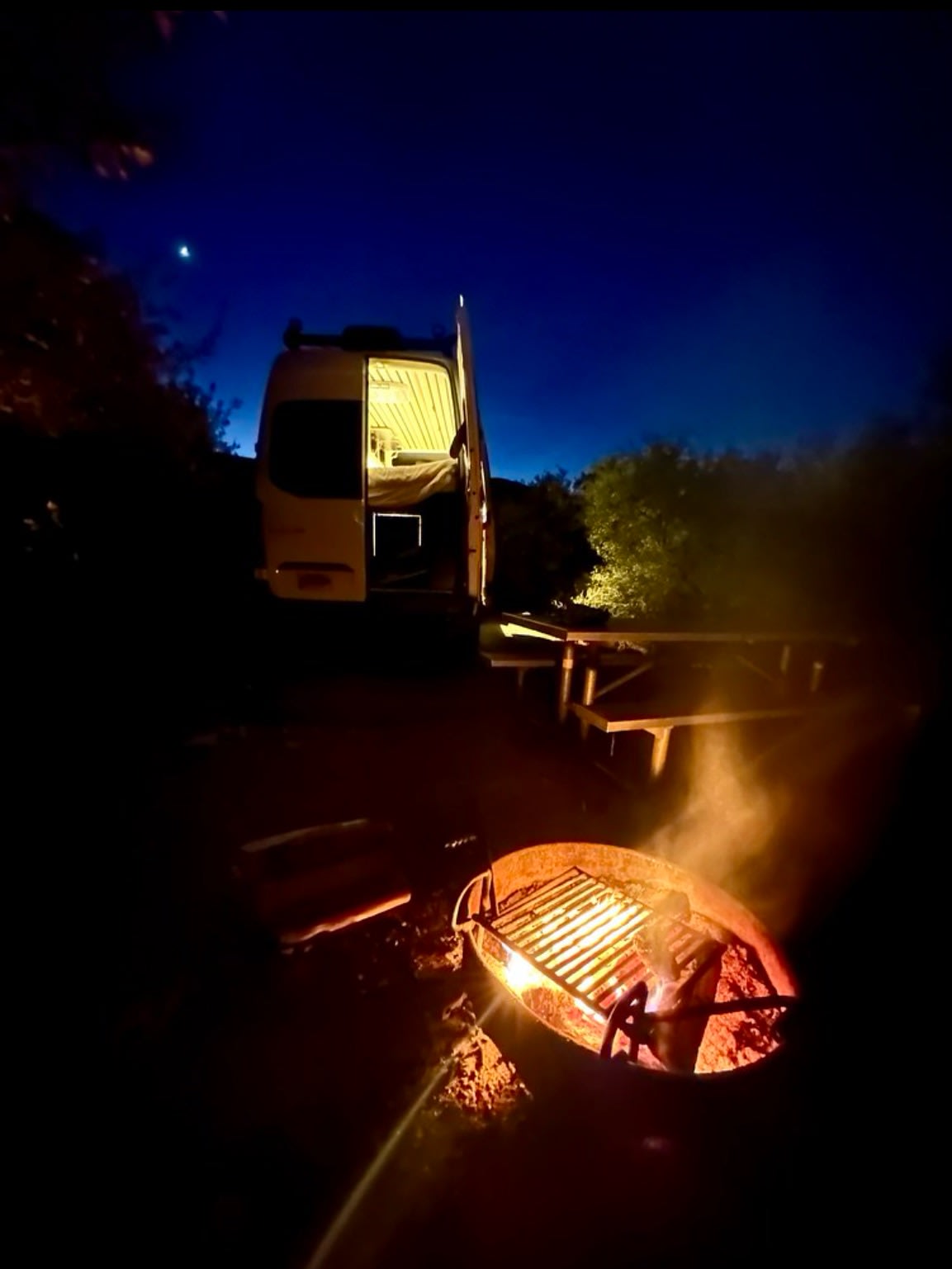 and compact kitchen.|Modern RV rental interior with a raised bed