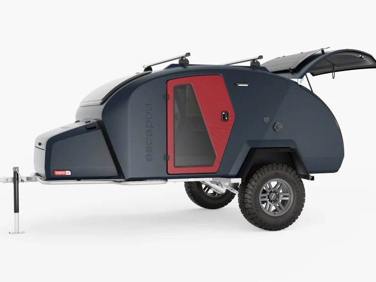Compact, dark teardrop trailer with red door and roof racks, perfect rv rental for rugged outdoor escapades.