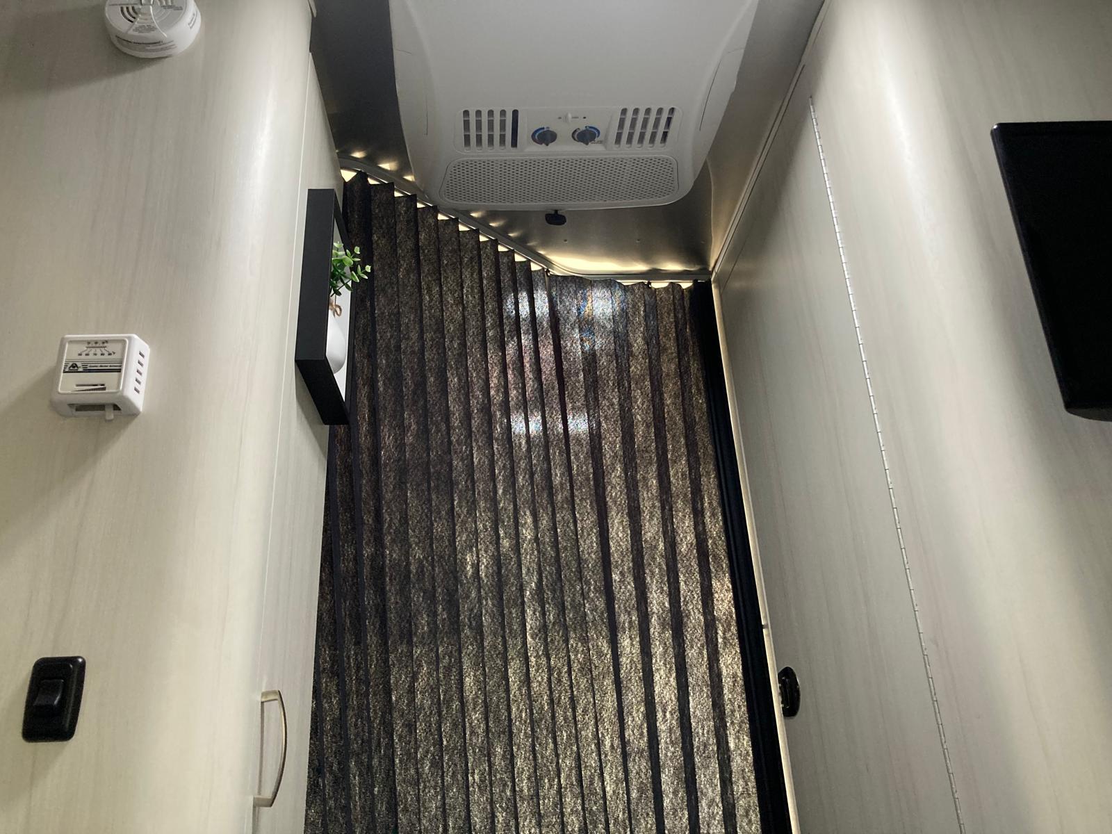 RV rental interior: ceiling AC, modern LED strip lighting, and blackout blinds for comfort and privacy.