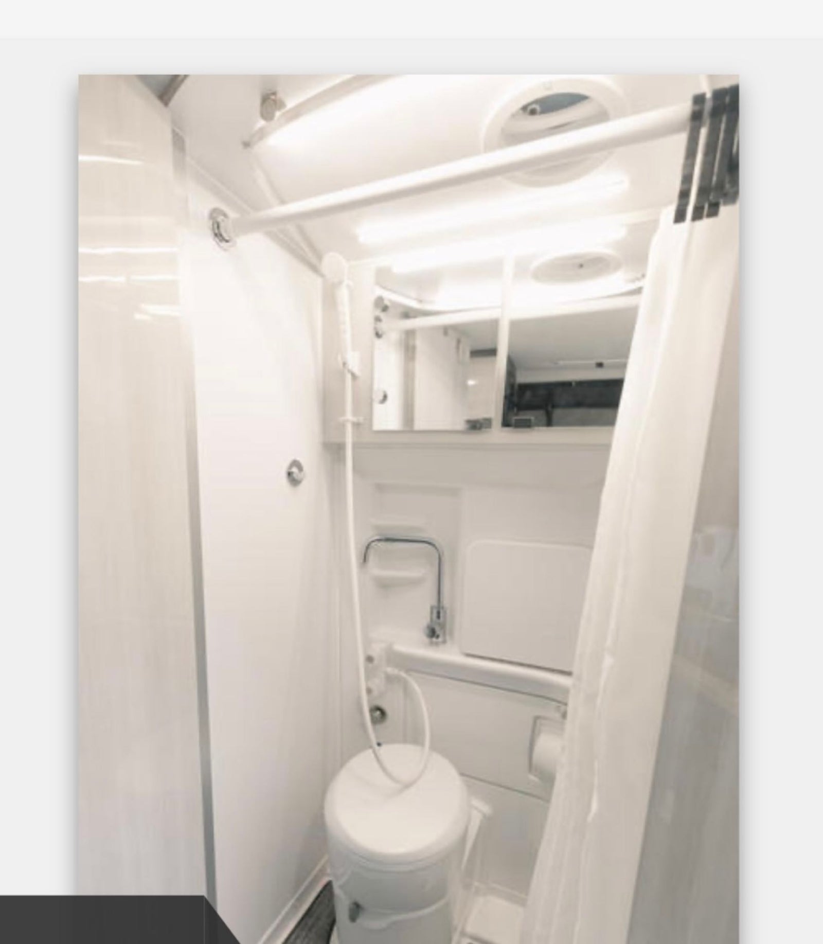 Interior of an RV rental bathroom: a compact, bright space with a toilet, sink, and integrated shower.