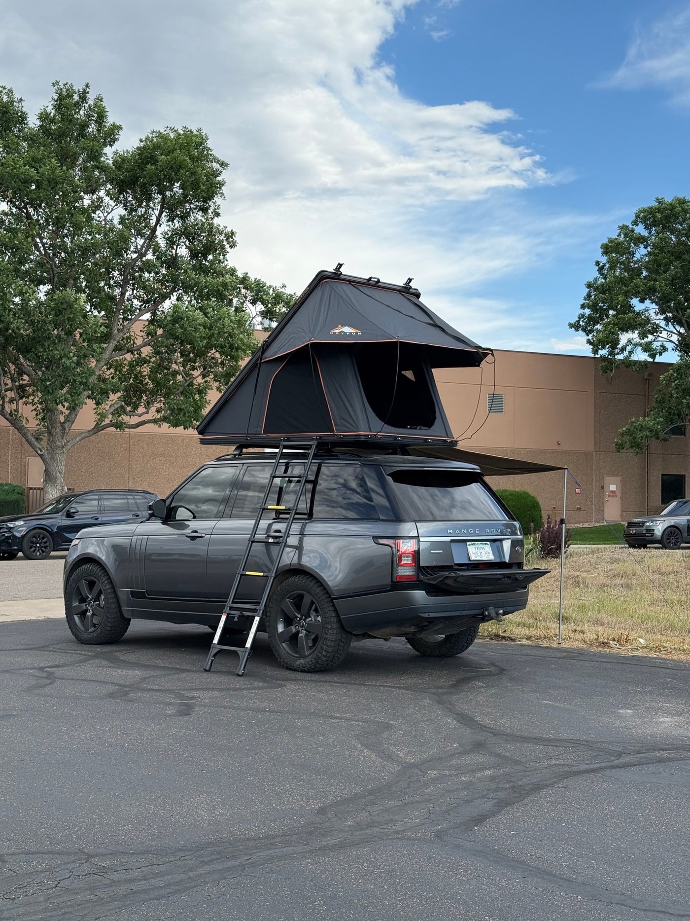 RV rental: Grey Range Rover SUV with deployed rooftop tent, ladder, and awning, ready for adventure camping. — photo 3