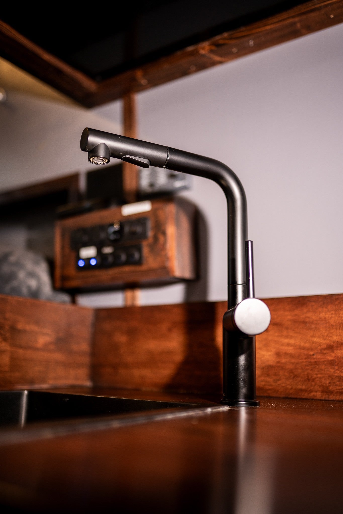A sleek black faucet and sink inside a well-equipped RV rental, highlighting quality kitchen amenities for travelers.