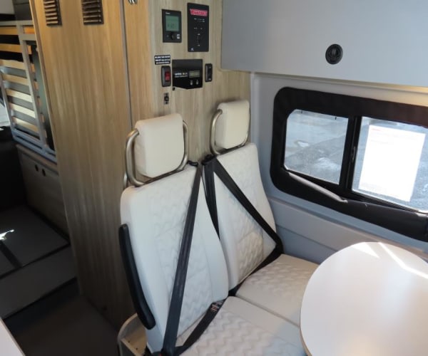 featuring a raised roof and side steps.|This rv rental features a compact stainless steel sink and chrome faucet on a white countertop