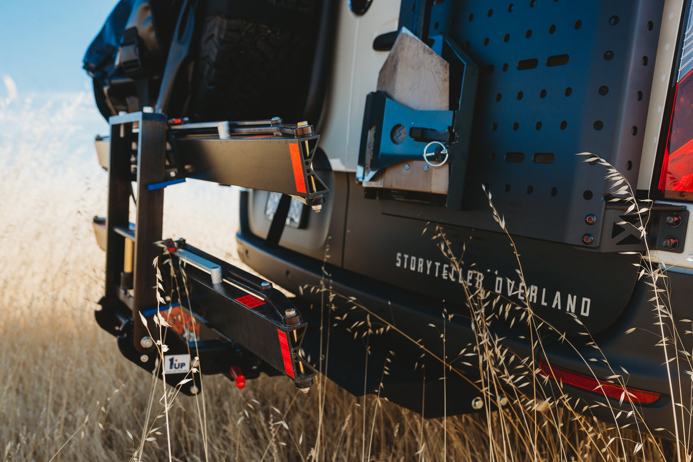 Rear of a Storyteller Overland RV rental, featuring a 1Up bike rack and utility panel, ready for outdoor adventures.