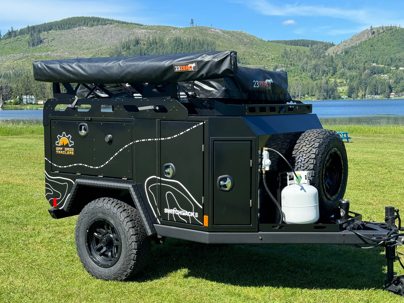 Off-Grid Trailers' rugged off-road camper with rooftop tent, a great RV rental for adventure travel by the lake.